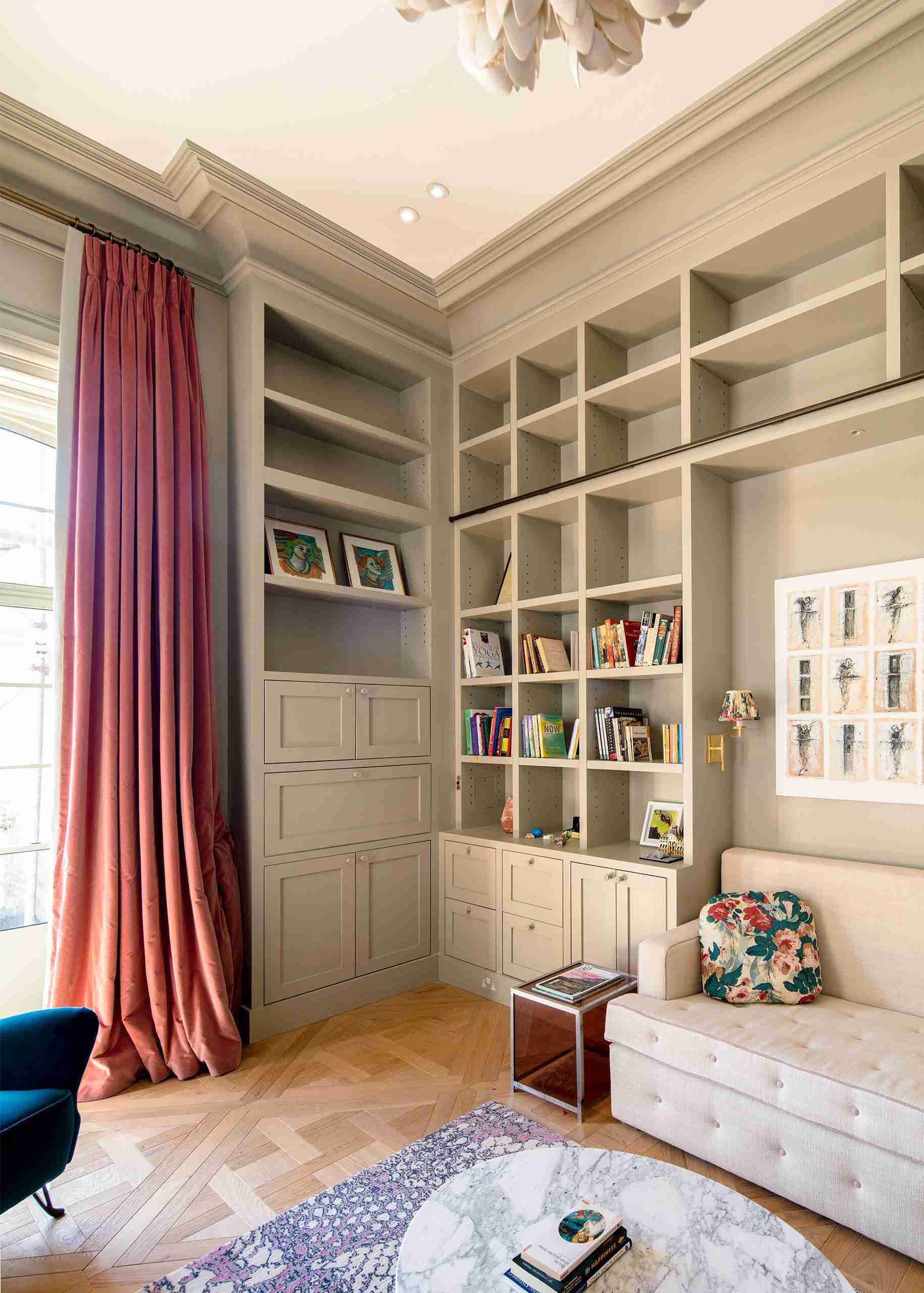 Luxurious room with bespoke grey built-in bookshelves, custom cabinetry, and tall curtains.