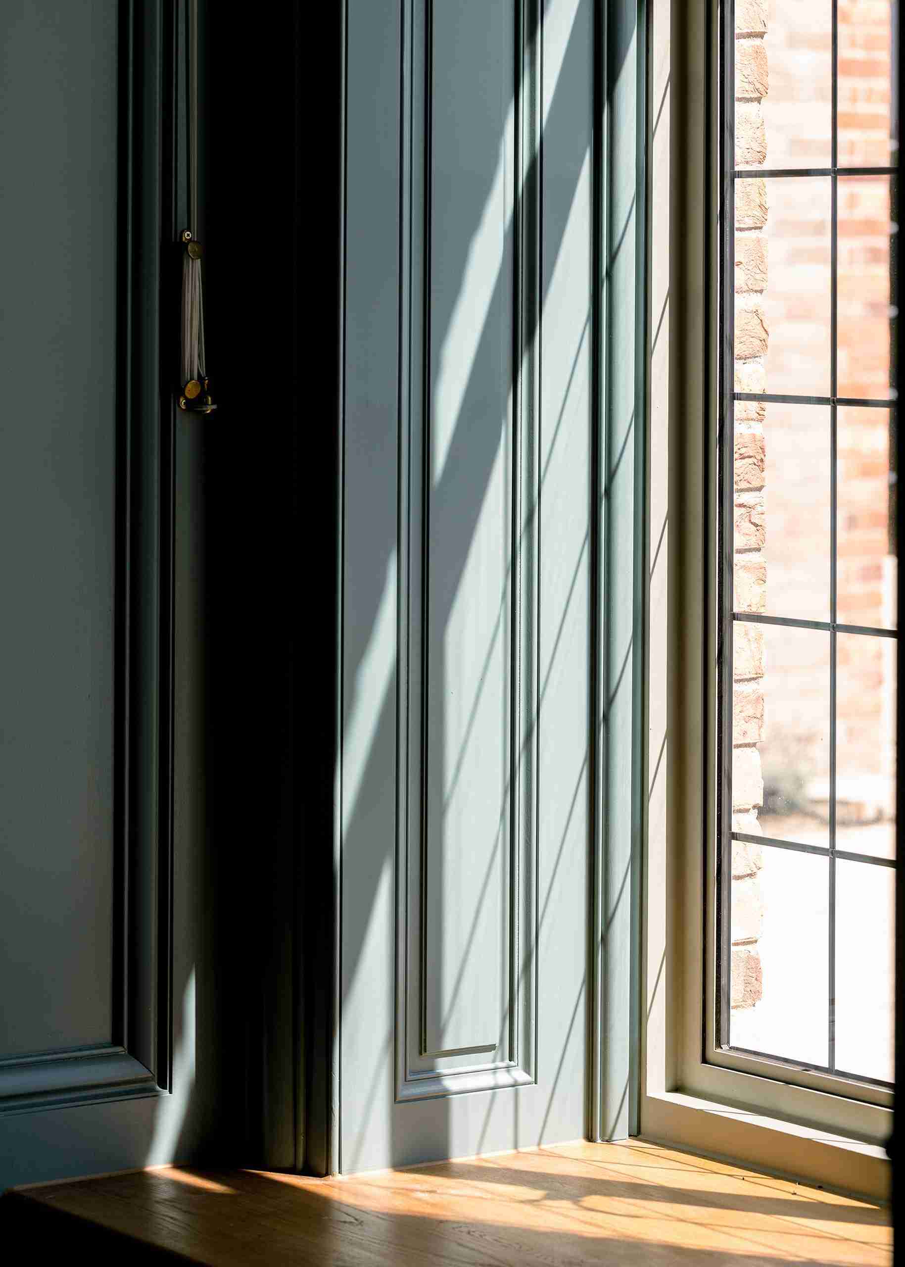 Close-up of bespoke wall paneling, timber window, and integrated detail.