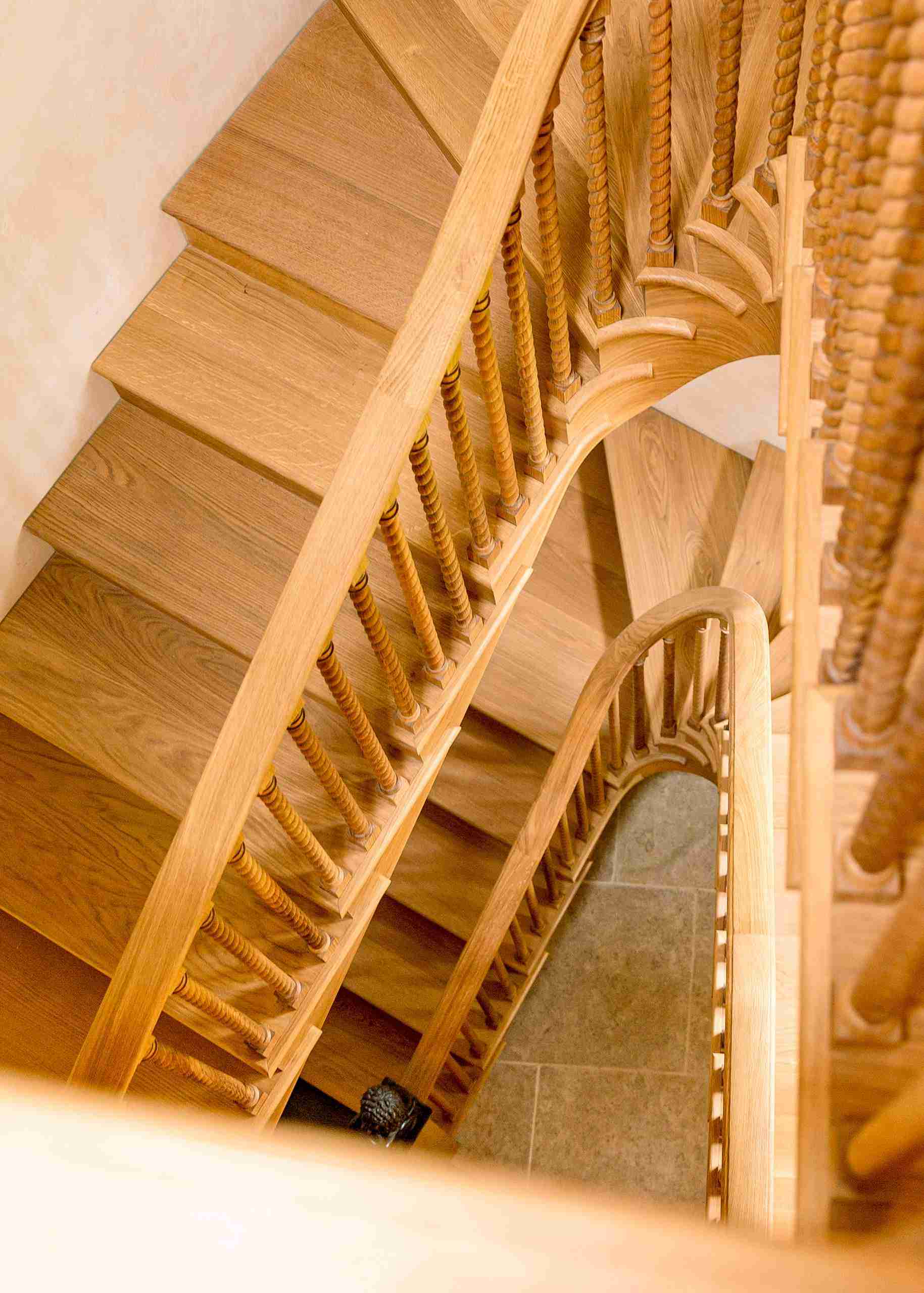 Birds eye view of a two and a half-curved staircase in the cotswolds created by kingerlee joiney.
