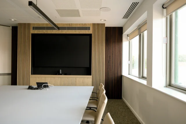 Our Joinery team recently completed the design, manufacture, and installation of two bespoke media walls for the boardrooms at Thomas House, the Kingerlee Ltd offices. Located just across from our workshop, this project demonstrates a balance of functionality and design clarity.  The media walls were developed to integrate the television and AV systems seamlessly while providing a considered focal point within the space.  Material Specification: ▪Carcase and doors: Ash-veneered MDF finished in silver-grey Osmo oil. ▪Unit top: Birch plywood with a black Formica laminate for durability and contrast. ▪Front slats: Solid ash finished to match the silver-grey tone, backed with Camira Main Line Flax ‘Upminster’ fabric. ▪Rear slats: American black walnut finished in ebony Osmo oil, set against Camira Main Line Flax ‘Edgware’ fabric.  The finished installation achieves a clean, cohesive aesthetic and the Kingerlee Ltd team are pleased with their new refurbished boardrooms!