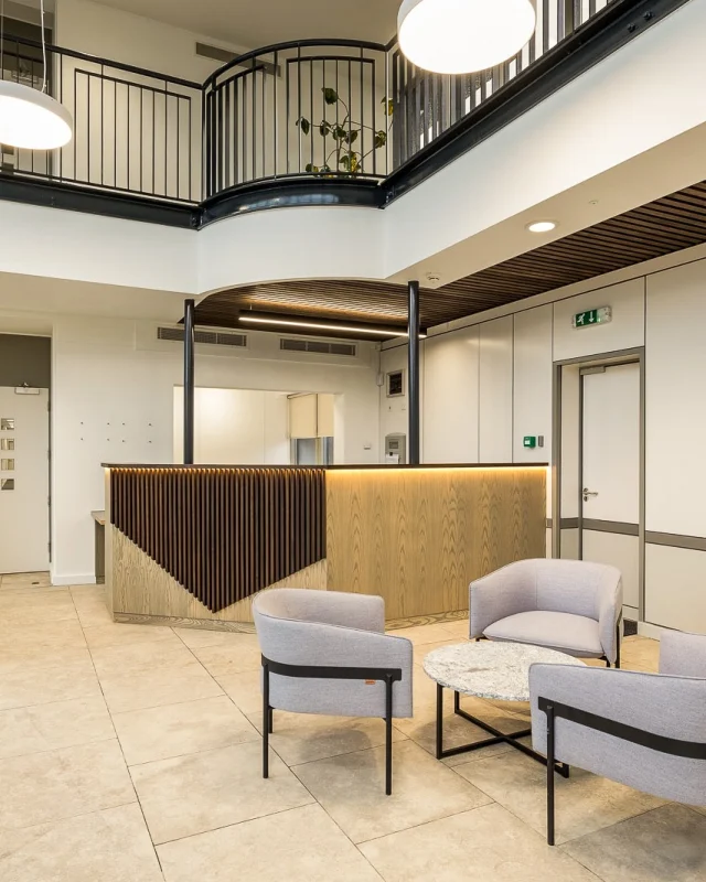 This bespoke reception desk and panelled ceiling were designed, crafted, and installed by our team for Thomas House, the head office of Kingerlee Ltd, replacing an outdated desk with a contemporary centrepiece.  We set out to create a natural yet modern reception area that complements the newly refurbished and welcoming entrance space for both staff and visitors.  The desk is meticulously constructed with a veneered MDF carcass and drawer boxes, finished in Grey Pearl Osmo Oil for a refined, soft sheen. The front slats, made from American Black Walnut and finished in Ebony Osmo Oil, add warmth and contrast. Behind these, Camira Fabrics main line flax (Camden) panels introduce subtle texture and colour. The worktop, crafted from birch ply laminated with dust grey Formica, showcases the natural ply edges for a distinctive handcrafted detail.  If you’re looking to create a unique piece for your space, we’d love to help. Contact Jonathan Watts, Joinery Director – jonathan.watts@kingerlee.co.uk  #ReceptionDesk #Joinery #KingerleeJoinery #JoineryOxfordshire